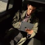 Man using an iPad Pro while sitting in a car.