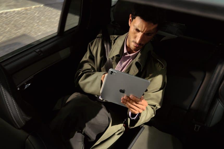 Man using an iPad Pro while sitting in a car.
