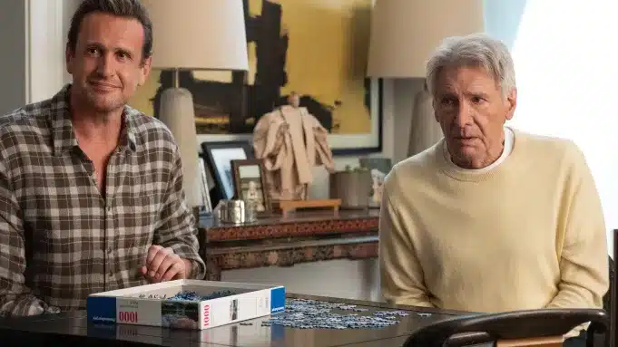 Jason Segel and Harrison Ford sit at a table working on a puzzle in a scene from Shrinking Season 3.