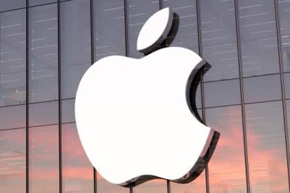 Apple logo on a glass building at sunset.