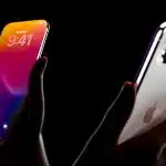 Hands holding an iPhone 20 prototype showing the front display and triple-camera back design.