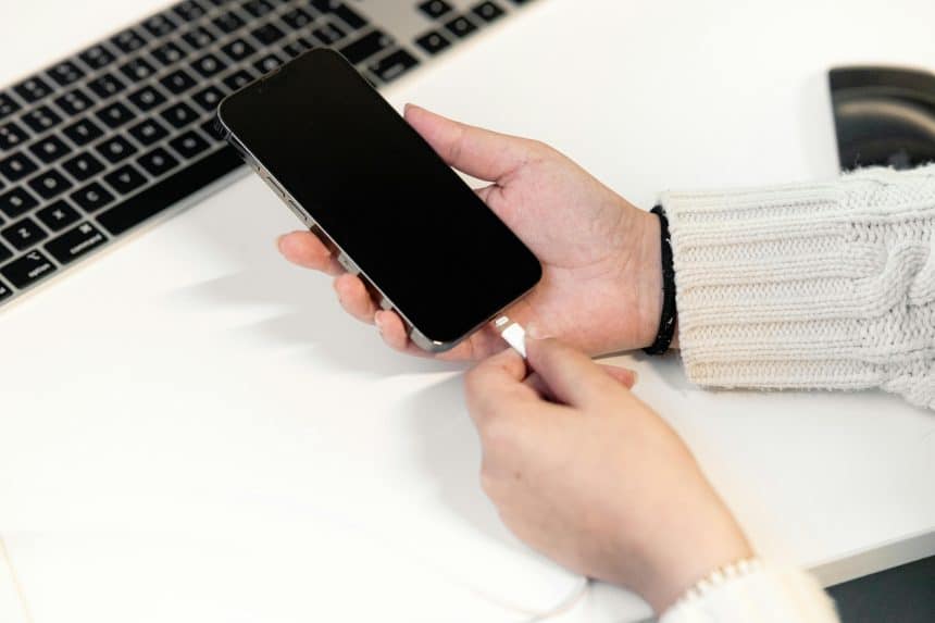 iPhone with low battery warning on nightstand, highlighting student concerns about overnight drain