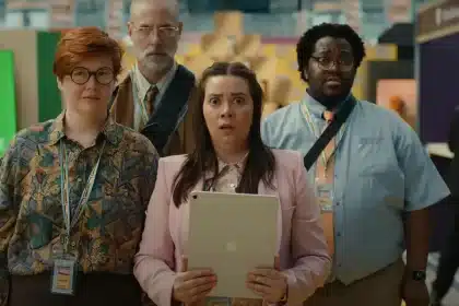 Four coworkers from Apple’s “Underdogs” ad look shocked while holding an iPad at a tech convention.
