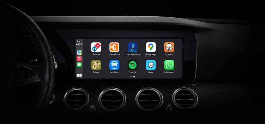 Car dashboard display showing Apple CarPlay apps on the screen.