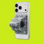 iPhone with a speckled gray grip attached on a bright green background.