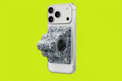 iPhone with a speckled gray grip attached on a bright green background.