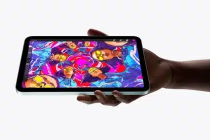A hand holding an iPad mini displaying vibrant digital artwork.