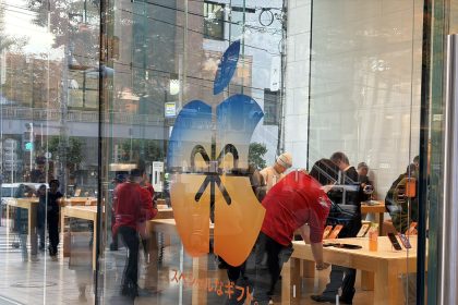 Holiday-themed Apple Store display in Tokyo with customers inside.