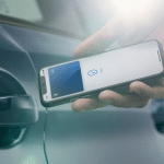 Person using an iPhone to unlock a car door with a digital car key.