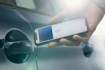 Person using an iPhone to unlock a car door with a digital car key.