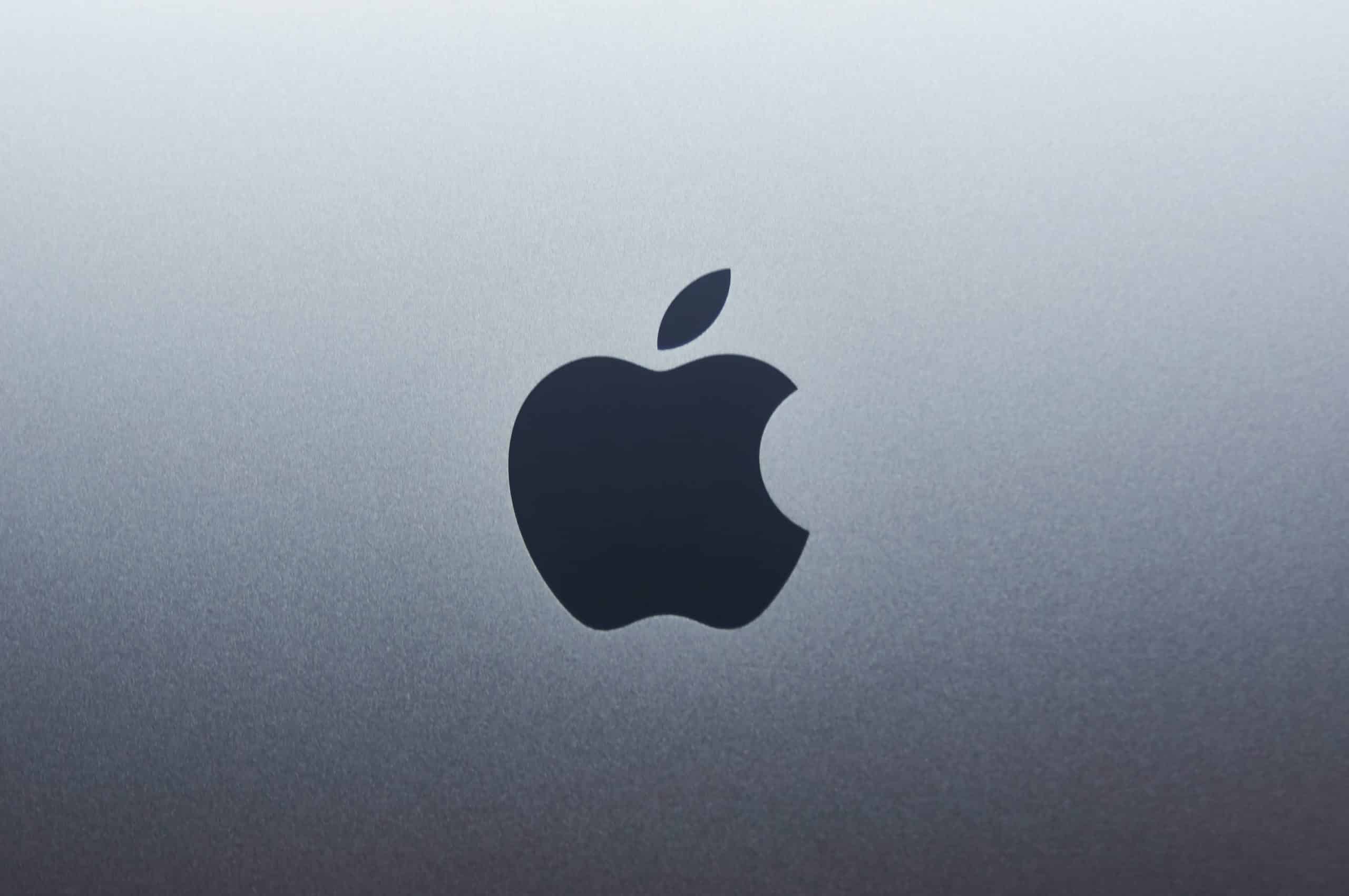 Close-up of the Apple logo on a silver device.