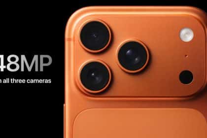 Close-up of an orange iPhone with three 48MP camera lenses on the back.