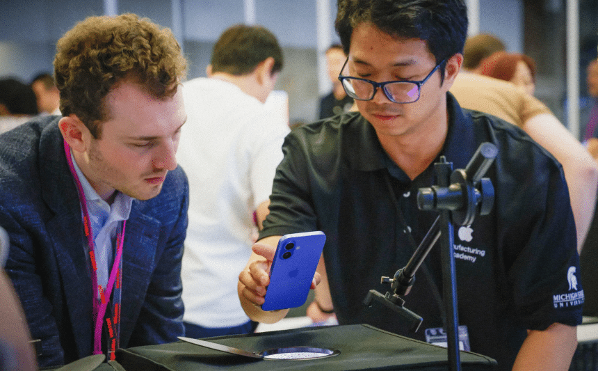 Apple Manufacturing Academy staff demonstrating a smartphone inspection process.