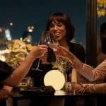 Three women clinking glasses at a dinner table.