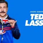 Jason Sudeikis as Ted Lasso holding a teacup and saucer.