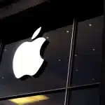 Apple logo on a storefront at night.