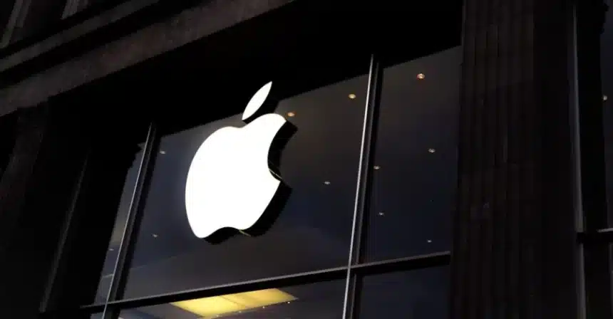 Apple logo on a storefront at night.