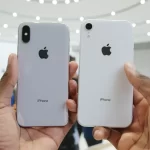 Two iPhones held side by side, showing their backs.
