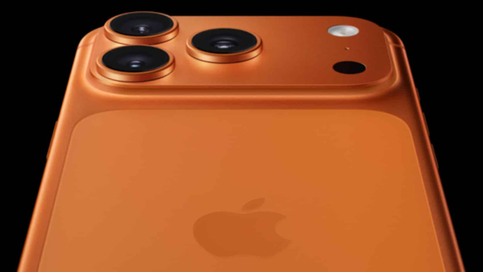 Close-up of an orange iPhone with triple rear cameras.