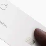 Apple Card held in hand showing the cardholder name.