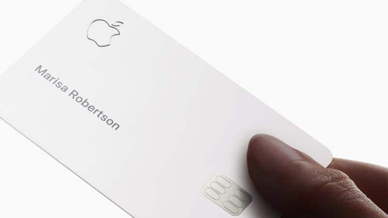 Apple Card held in hand showing the cardholder name.