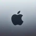 Apple logo on a metallic background.