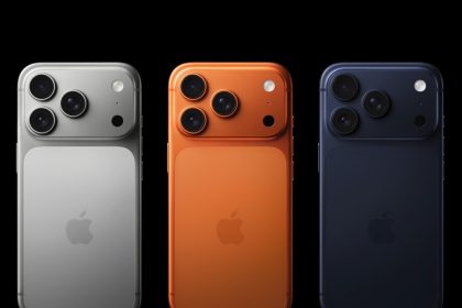 Three iPhones shown from the back in silver, orange, and dark blue colors.