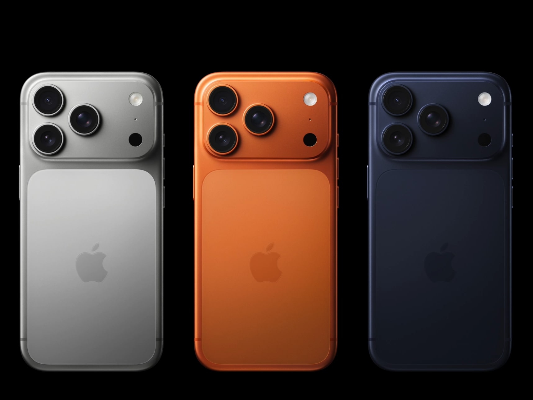 Three iPhones shown from the back in silver, orange, and dark blue.