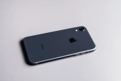 Black iPhone lying face down on a light surface.