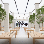 Apple Regent Street store interior with display tables and trees.