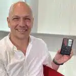 Tony Fadell smiling while holding an iPod.
