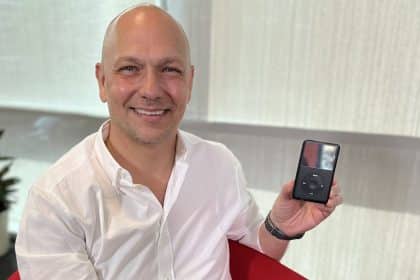 Tony Fadell smiling while holding an iPod.