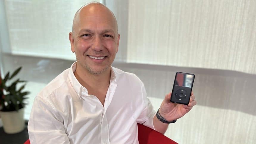 Tony Fadell smiling while holding an iPod.