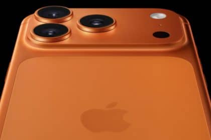 Close-up of an orange iPhone Pro showing its triple camera lenses.