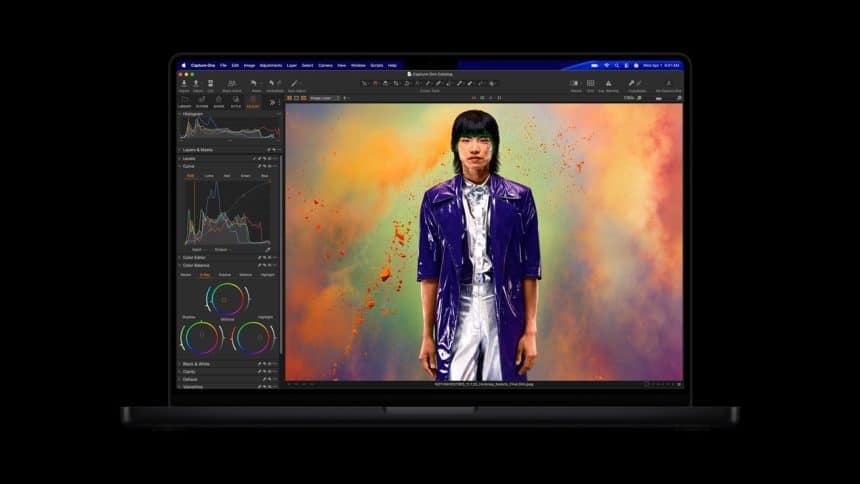 MacBook Pro displaying professional photo editing software on screen.