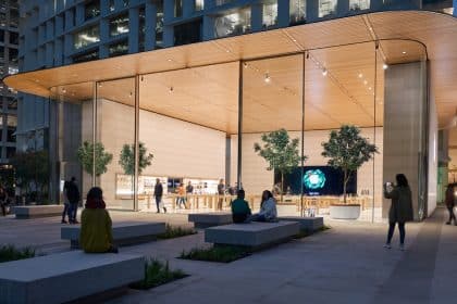 Modern Apple Store with glass walls and people outside at night.