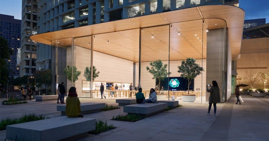 Modern Apple Store with glass walls and people outside at night.