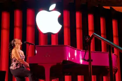 Alicia Keys performing at a pink piano under a glowing Apple logo.