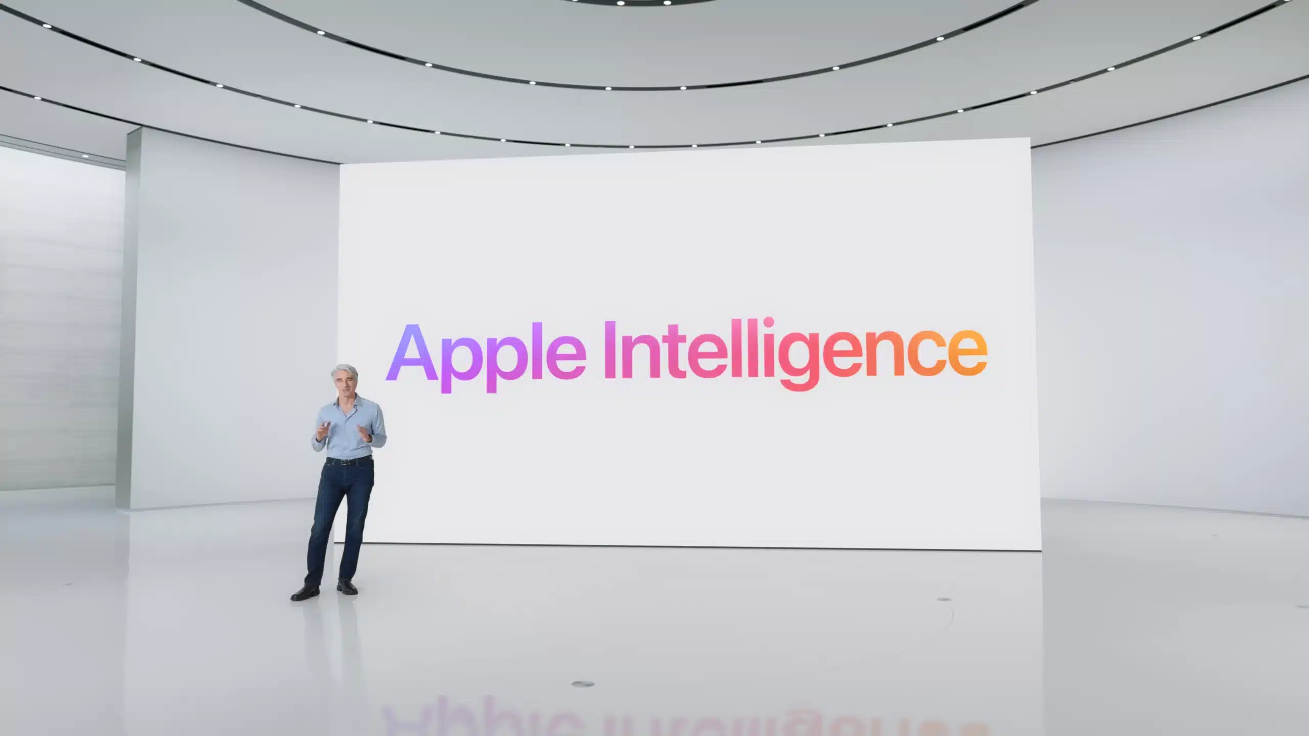 Apple executive presenting “Apple Intelligence” on a large screen in a modern auditorium.
