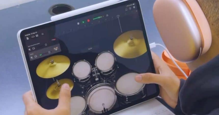 Person using an iPad drum app with headphones.