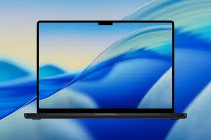 MacBook displaying macOS Tahoe wallpaper on screen.