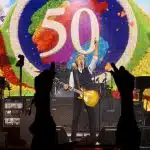 Paul McCartney performing on stage with a guitar during Apple’s 50th anniversary celebration.