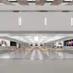 Apple retail store interior with display tables and products.