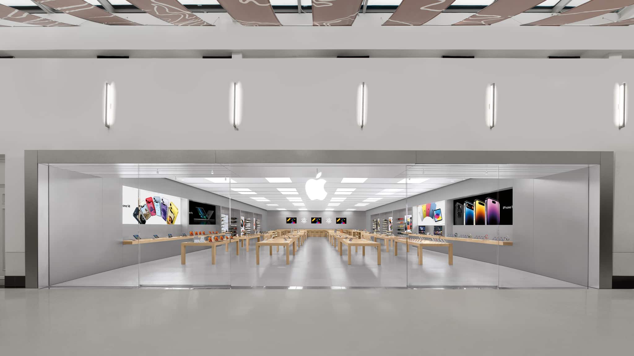 Apple retail store interior with display tables and products.