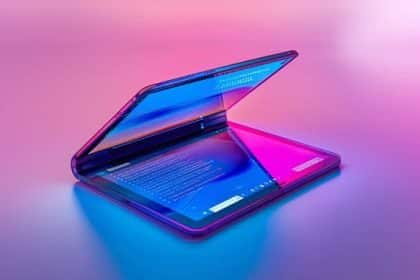 Foldable tablet partially open with dual screens on a colourful background.