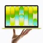 MacBook Neo displayed on a hand with colourful screen design.