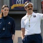 Ted Lasso coaching with a woman on a football field.