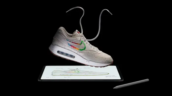 Sneaker floating above a tablet with a stylus.