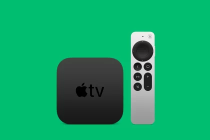 Apple TV box with remote on green background.