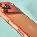 Orange iPhone with triple camera setup shown from the back.